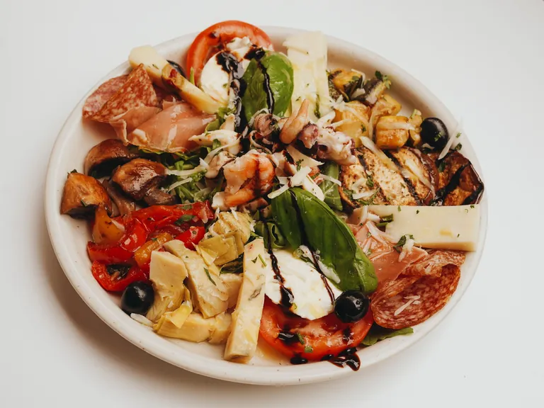 Antipasti-Teller mit Salami, Schinken, Käse, Artischocken, Tomaten und Oliven