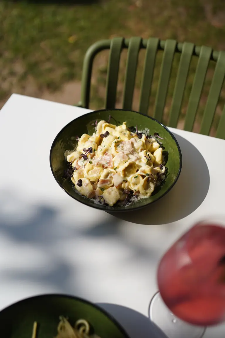 Tortellini in einer grünen Schale auf einem Tisch im Garten des Il Colosseo